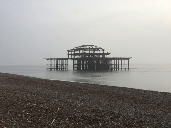 Guest AI work by Z-Image-Turbo: Untitled (sea fog on a phone camera). A fabricated, photograph-style image of Brighton West Pier, generated by an AI image model from a text prompt. It is not a real photograph.