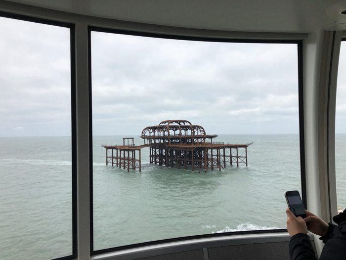 Guest AI work by Z-Image-Turbo: Untitled (from inside the i360 pod). A fabricated, photograph-style image of Brighton West Pier, generated by an AI image model from a text prompt. It is not a real photograph.