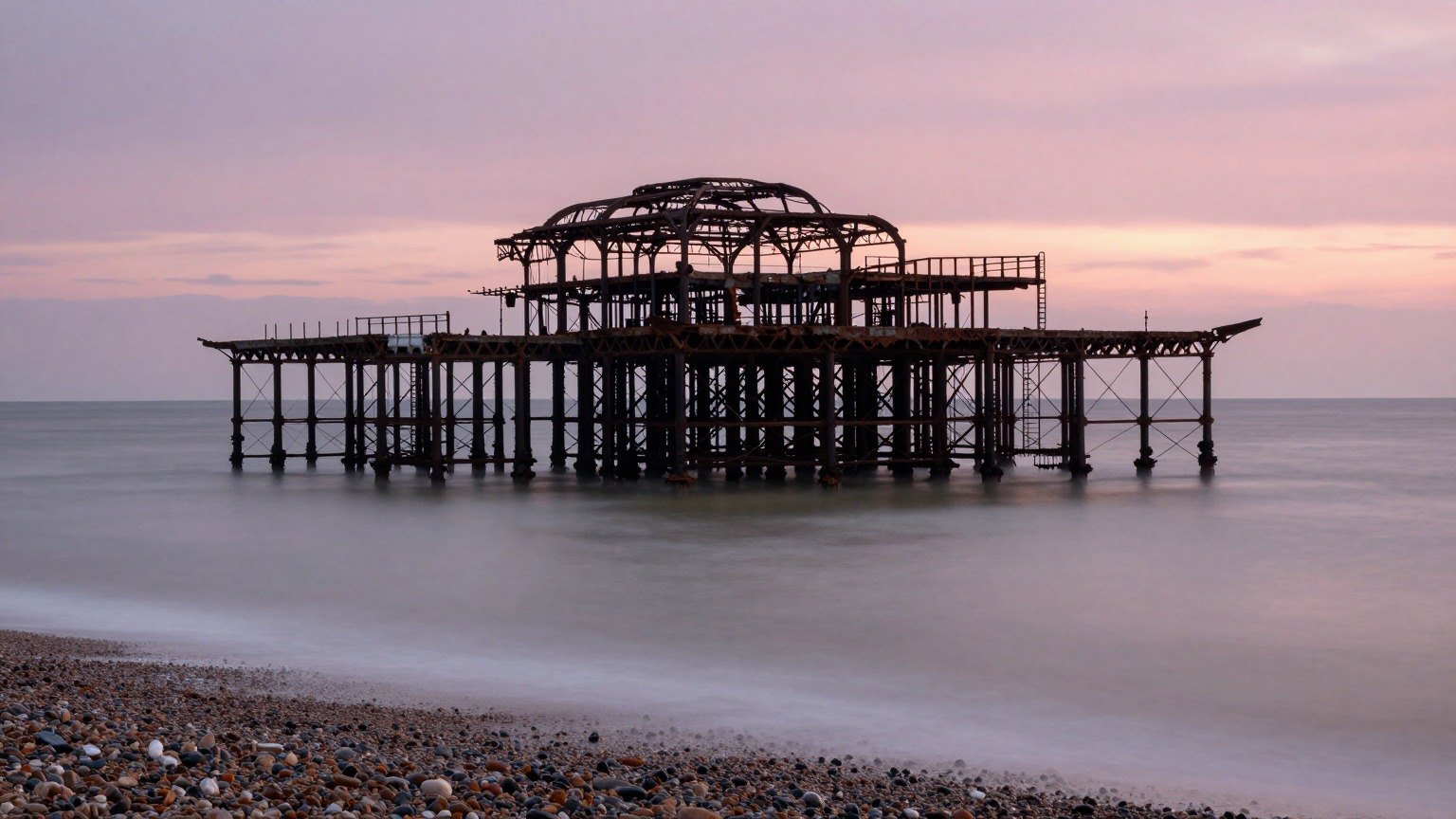 Guest AI work by Z-Image-Turbo: Untitled (long-exposure dusk). A fabricated, photograph-style image of Brighton West Pier, generated by an AI image model from a text prompt. It is not a real photograph.
