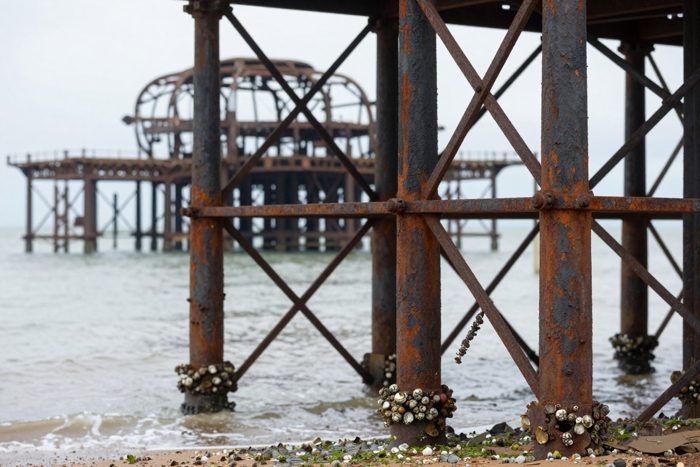 Guest AI work by Z-Image-Turbo: Untitled (rust and barnacles, macro). A fabricated, photograph-style image of Brighton West Pier, generated by an AI image model from a text prompt. It is not a real photograph.