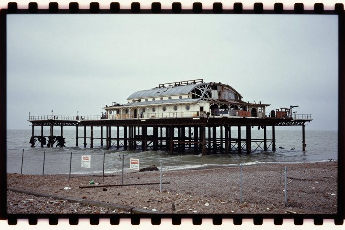 Guest AI work by Z-Image-Turbo: Untitled (Kodachrome slide, 1983). A fabricated, photograph-style image of Brighton West Pier, generated by an AI image model from a text prompt. It is not a real photograph.