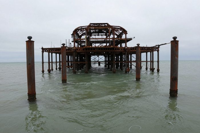 Guest AI work by Z-Image-Turbo: Untitled (low, from the water). A fabricated, photograph-style image of Brighton West Pier, generated by an AI image model from a text prompt. It is not a real photograph.