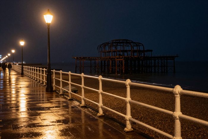 Guest AI work by Z-Image-Turbo: Untitled (wet promenade at night). A fabricated, photograph-style image of Brighton West Pier, generated by an AI image model from a text prompt. It is not a real photograph.