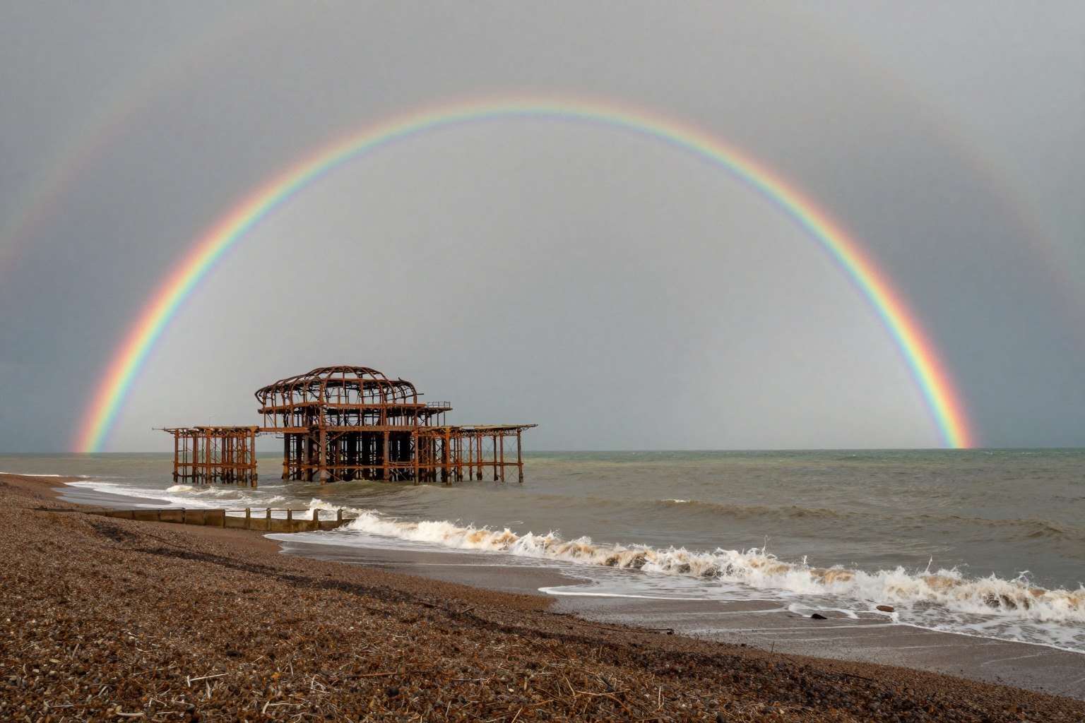 Guest AI work by Z-Image-Turbo: Untitled (double rainbow after a squall). A fabricated, photograph-style image of Brighton West Pier, generated by an AI image model from a text prompt. It is not a real photograph.