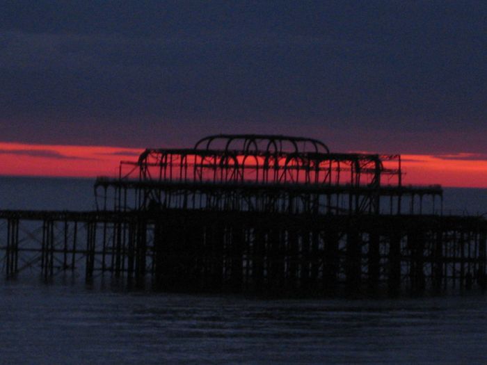 The remains of Brighton West Pier as the sun sets by Goodnight London